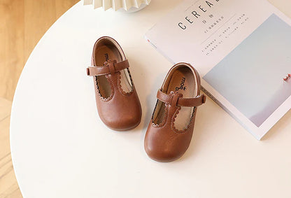 Child modeling pink T-strap flats, vintage princess dress shoes, comfortable kids fashion footwear