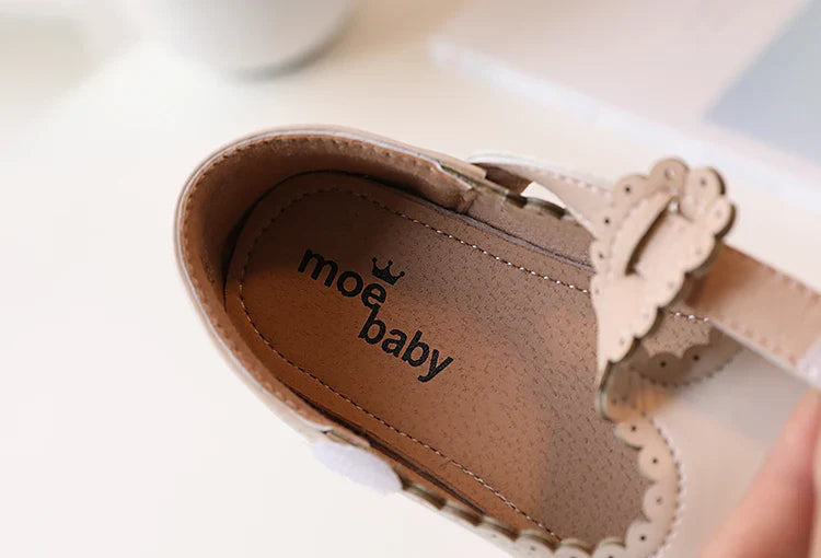 Close-up on the T-strap design of girls' retro flats, vintage princess dress shoes, secure fit