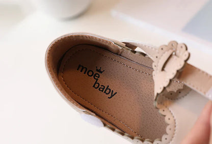 Close-up on the T-strap design of girls' retro flats, vintage princess dress shoes, secure fit