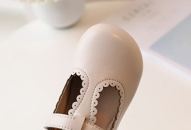 Girls' retro T-strap flats on a wooden floor, showcasing vintage princess dress shoes aesthetic