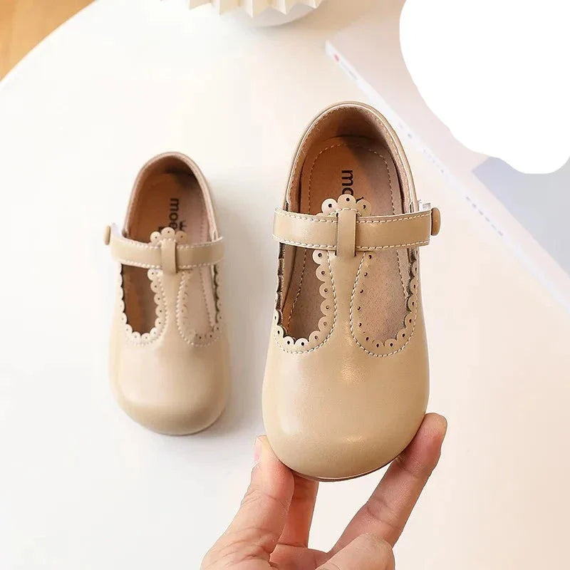 Side profile of a girl's red T-strap flat shoe, vintage princess design, comfortable kids dress shoe