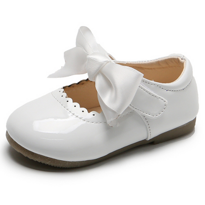 Toddler girl's shiny silver princess party shoes with ribbon and lace bow, comfortable slip-on design