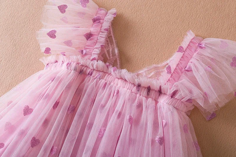 Close-up of the delicate wing detail on a girls' back bow tulle party dress, kids fashion.