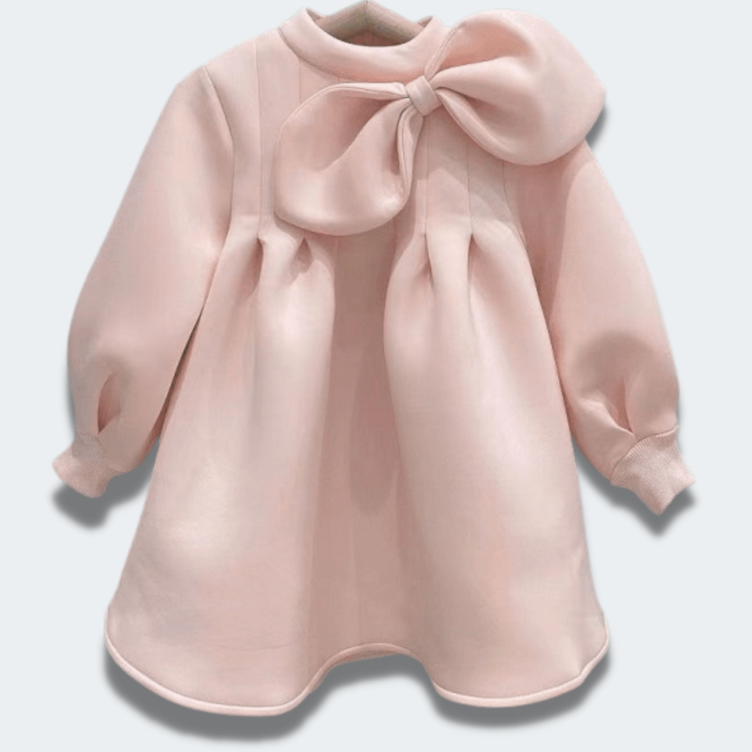 Close-up of a pink ruched toddler dress for girls, featuring a charming bow detail on the front