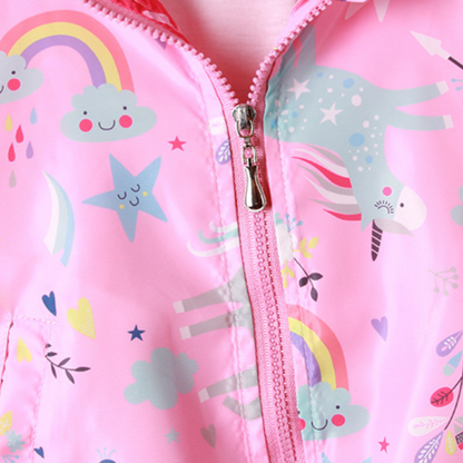 Toddler girl smiling in a colorful unicorn windbreaker jacket, perfect for outdoor playwear