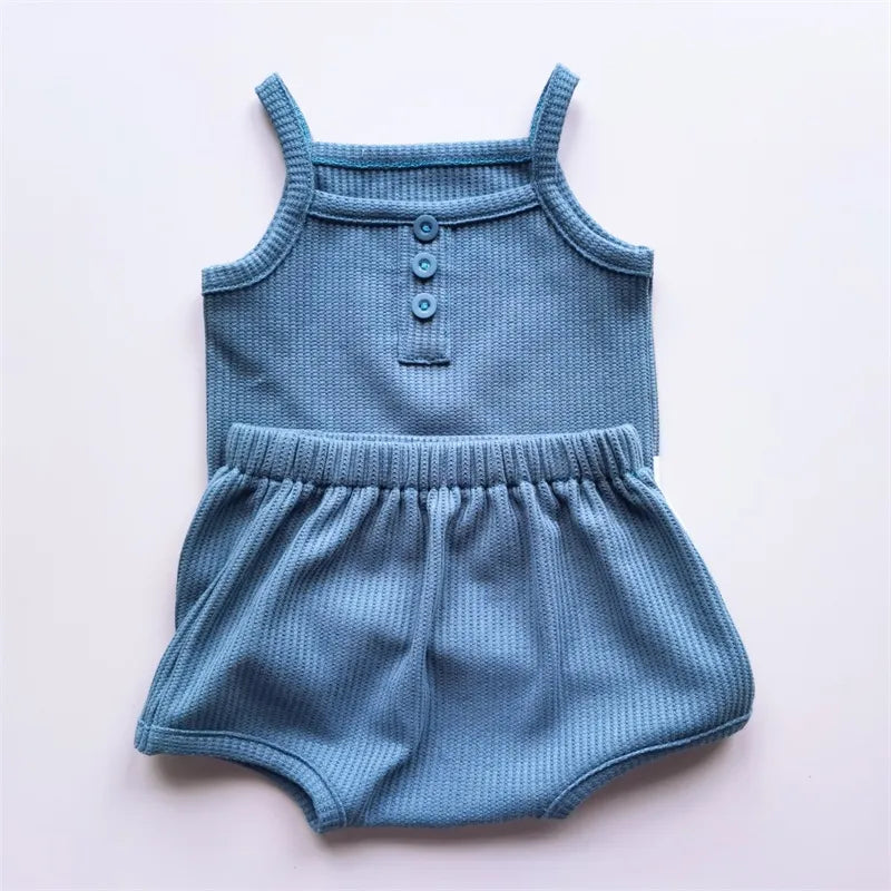Detail of the elastic waistband on girls' cotton shorts, part of a sleeveless set