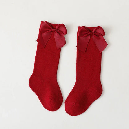 Display of multiple pairs of colorful cotton knee-high bow socks for girls; summer accessories
