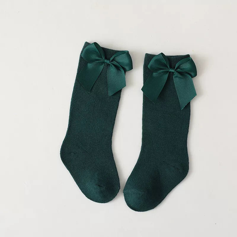 Unworn pair of soft cotton knee-high bow socks for toddlers; comfortable children's wear