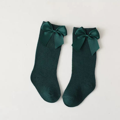 Unworn pair of soft cotton knee-high bow socks for toddlers; comfortable children's wear