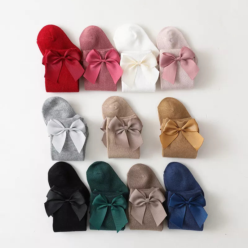 Girls' white cotton knee-high bow socks with a delicate bow detail; perfect for summer