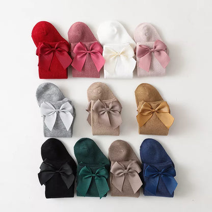 Girls' white cotton knee-high bow socks with a delicate bow detail; perfect for summer