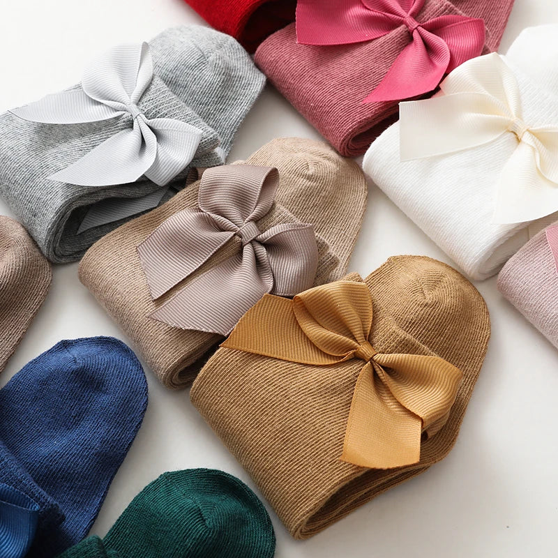Assorted pack of girls' cotton knee-high bow socks in various colors; children's apparel