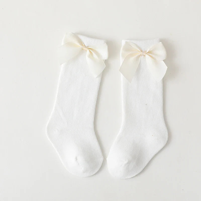 Detail shot of the mesh knit on girls' cotton knee-high bow socks; breathable summer wear
