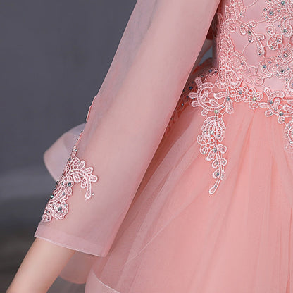 Full view of a girls' elegant white and pink beaded special occasion dress with flowy tulle skirt.