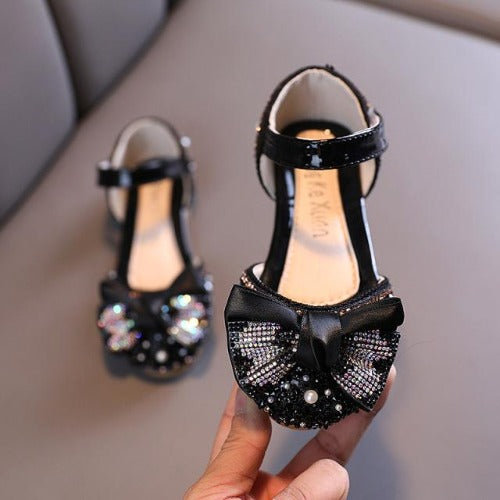 Close-up of girls' dress-up pearl and rhinestone adorned bow flats, comfortable kids fashion