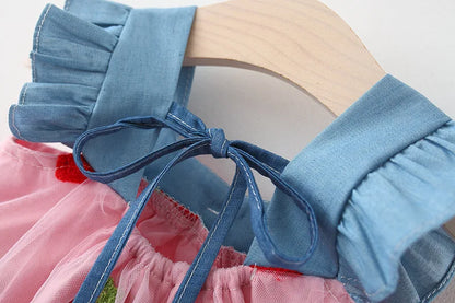 Back view of a lovely white girls' dress, showcasing strawberry embroidery and the bow detail.