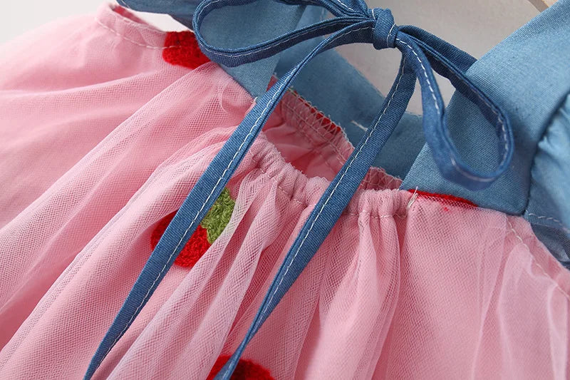 Pretty white summer dress for kids, featuring intricate strawberry embroidery and a charming bow.