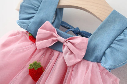 Full view of a white baby girl's summer dress with colorful strawberry embroidery and a tasteful bow.
