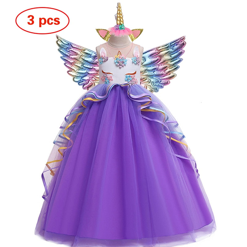Full shot of a happy girl wearing a pink winged unicorn ruffle dress, children's clothing.