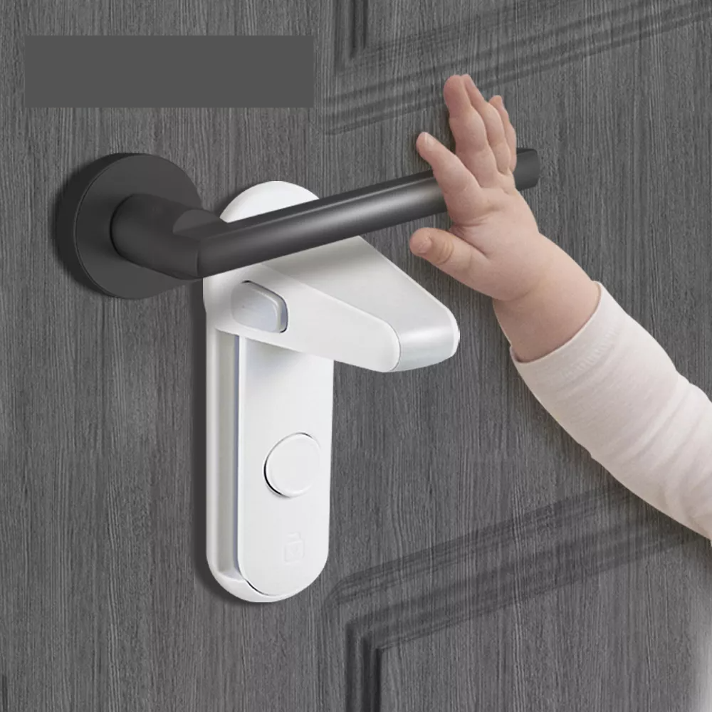 Gray childproof door lever lock installed on a white door, close-up for baby safety