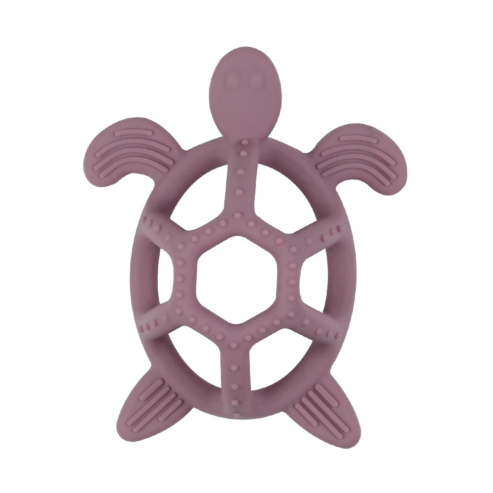 Green silicone turtle teether resting on a baby blanket, ready for use