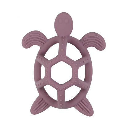 Green silicone turtle teether resting on a baby blanket, ready for use