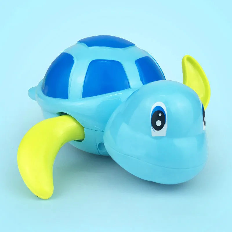 Green wind-up swimming turtle bath toy with a happy child's hands, promoting sensory play for babies
