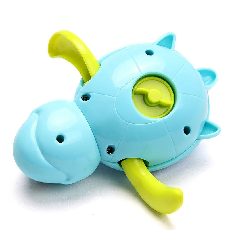 Child happily playing with a green wind-up swimming turtle bath toy in a bathtub, educational water toy