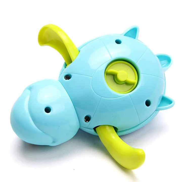Child happily playing with a green wind-up swimming turtle bath toy in a bathtub, educational water toy