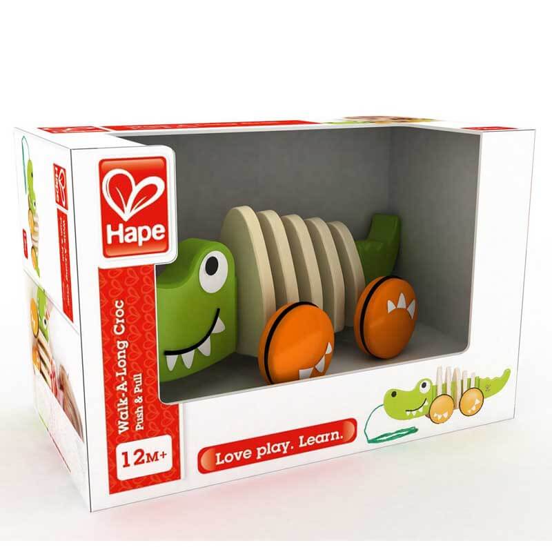 Toddler entertained by a wooden green crocodile pull toy, an educational and fun kids' accessory.