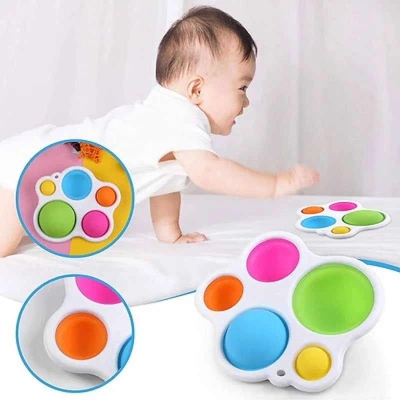 Close-up of a baby's joyful expression interacting with the white fine motor sensory board