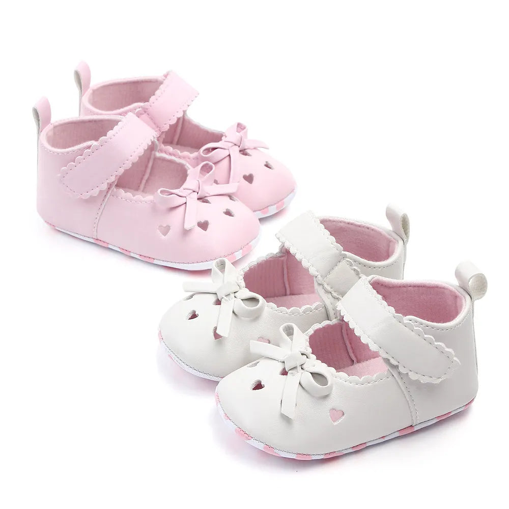 Infant girl's pink soft sole first walker shoes with cute bows, perfect for tiny feet
