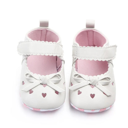 Soft sole baby girl shoes in white with adorable ribbon bows, ideal for first steps