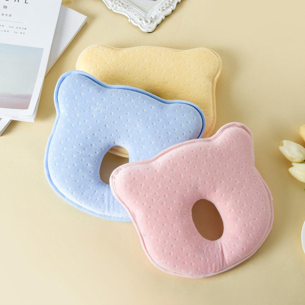 Close-up of a white memory foam baby pillow, ergonomic design for flat head prevention in infants.