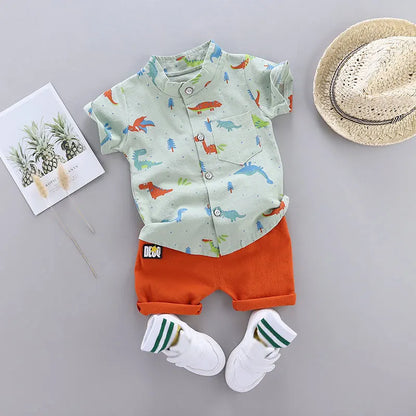 Complete infant toddler dinosaur print short sleeve outfit set. Includes shirt with stand-up collar and shorts.