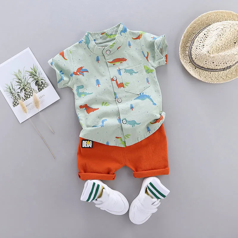 Full view of baby wearing dinosaur print short sleeve top and matching shorts. Comfortable toddler outfit.