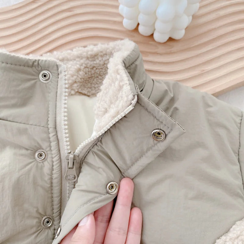 Toddler girl wearing a warm khaki fleece lambswool winter jacket, playing outdoors