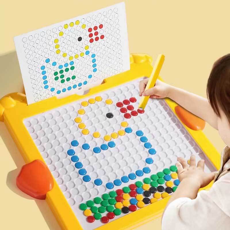 Kid smiling while drawing on a mess-free magnetic drawing board with a red stylus, educational toddler toy.