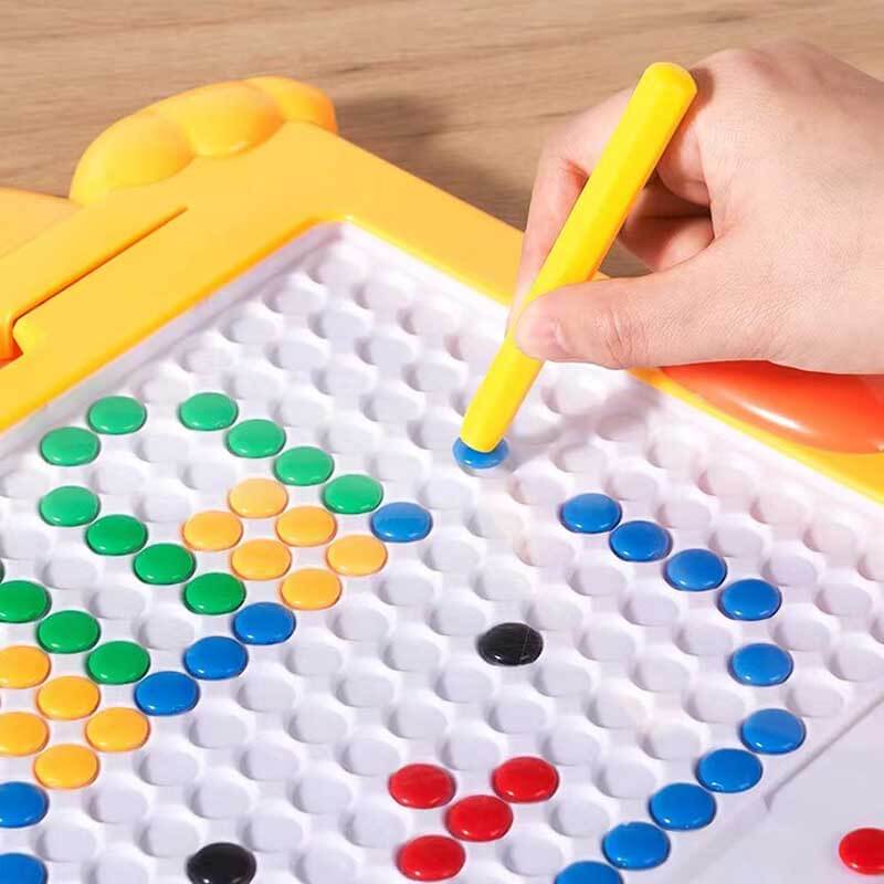 Toddler's hand holding a stylus, creating lines on a kids magnetic drawing board, preschool activity.