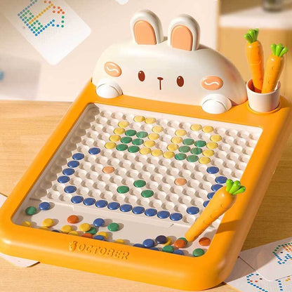Child concentrating while using a magnetic drawing board to create a picture, develops fine motor skills.