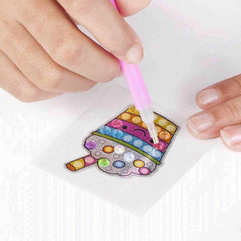 Child's hands working on a diamond painting kit, adding gems to a vibrant unicorn image with frame.