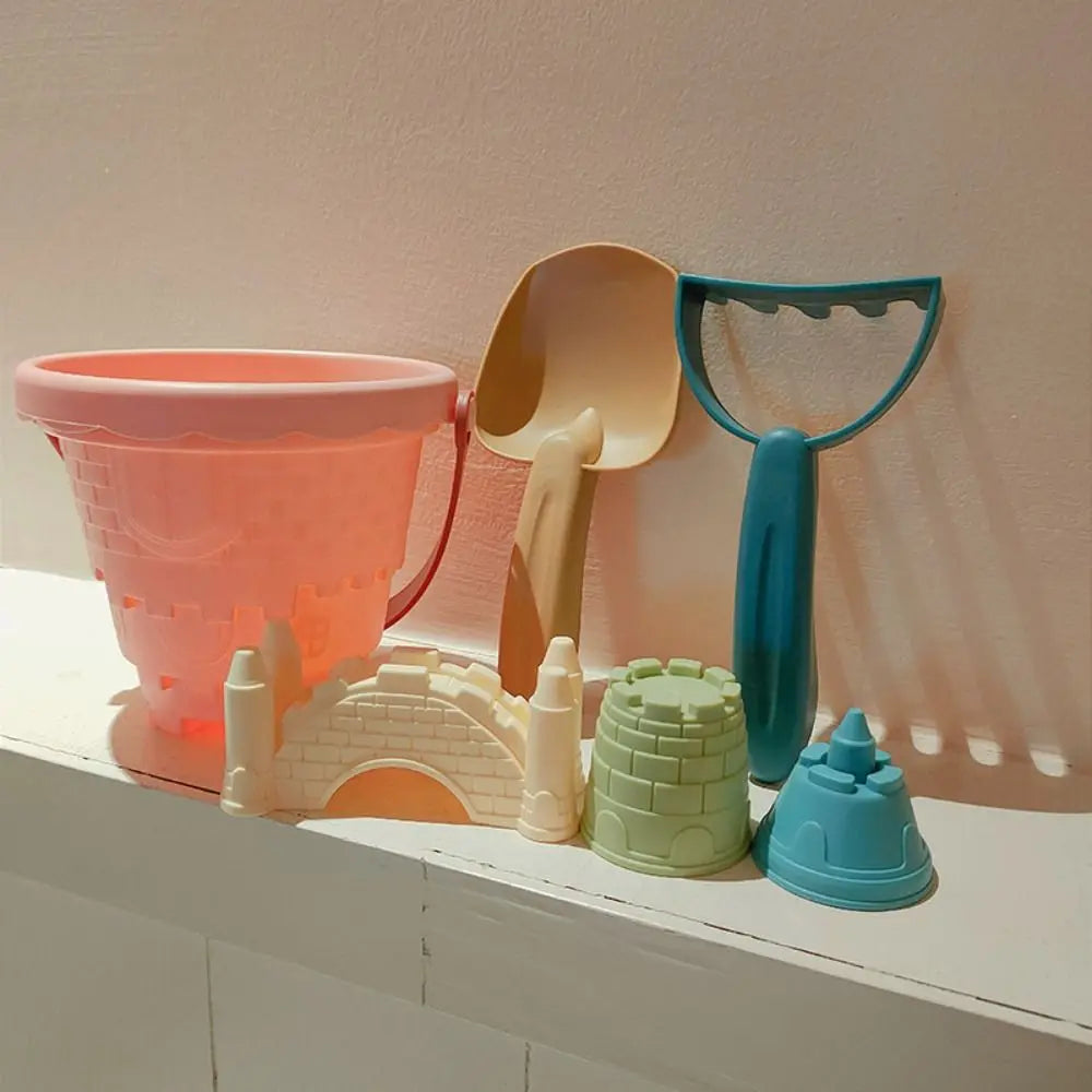 Children's 6-piece beach sand toy set, including a vibrant pink bucket and various molds