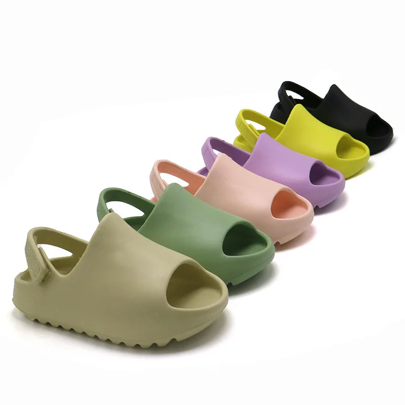 Kids adjustable blue summer sandals for boys, lightweight & waterproof, with velcro straps, on beach.