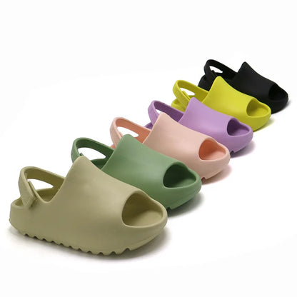 Kids adjustable blue summer sandals for boys, lightweight & waterproof, with velcro straps, on beach.