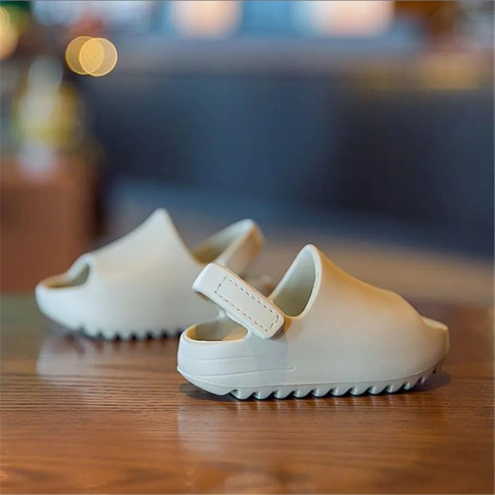 Child wearing blue adjustable summer sandals, playing in sand, ideal for beach & water activities.