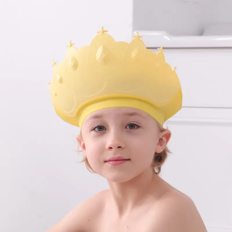 Close-up of kids adjustable shower cap showing the yellow cartoon crown detail and silicone material.