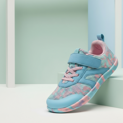 Side profile of a child's foot in a breathable barefoot non-slip sneaker, ergonomic design