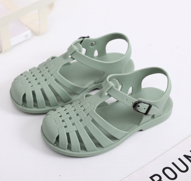 Close-up of the anti-slip sole on a pair of kids' beach and swim shoes, grey