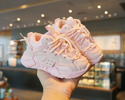 Toddler's feet in grey plush waterproof sports shoes, demonstrating the elastic closure and secure fit