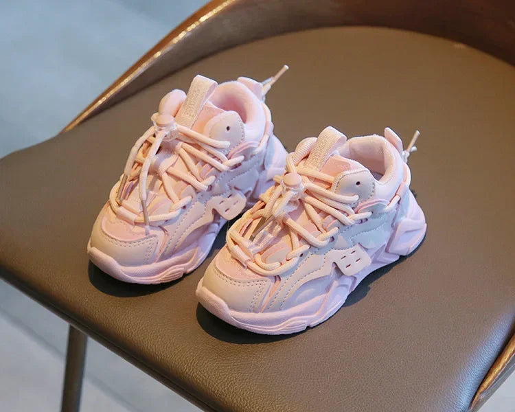Muddy kids' plush waterproof sports sneakers being cleaned, demonstrating their water-resistant features